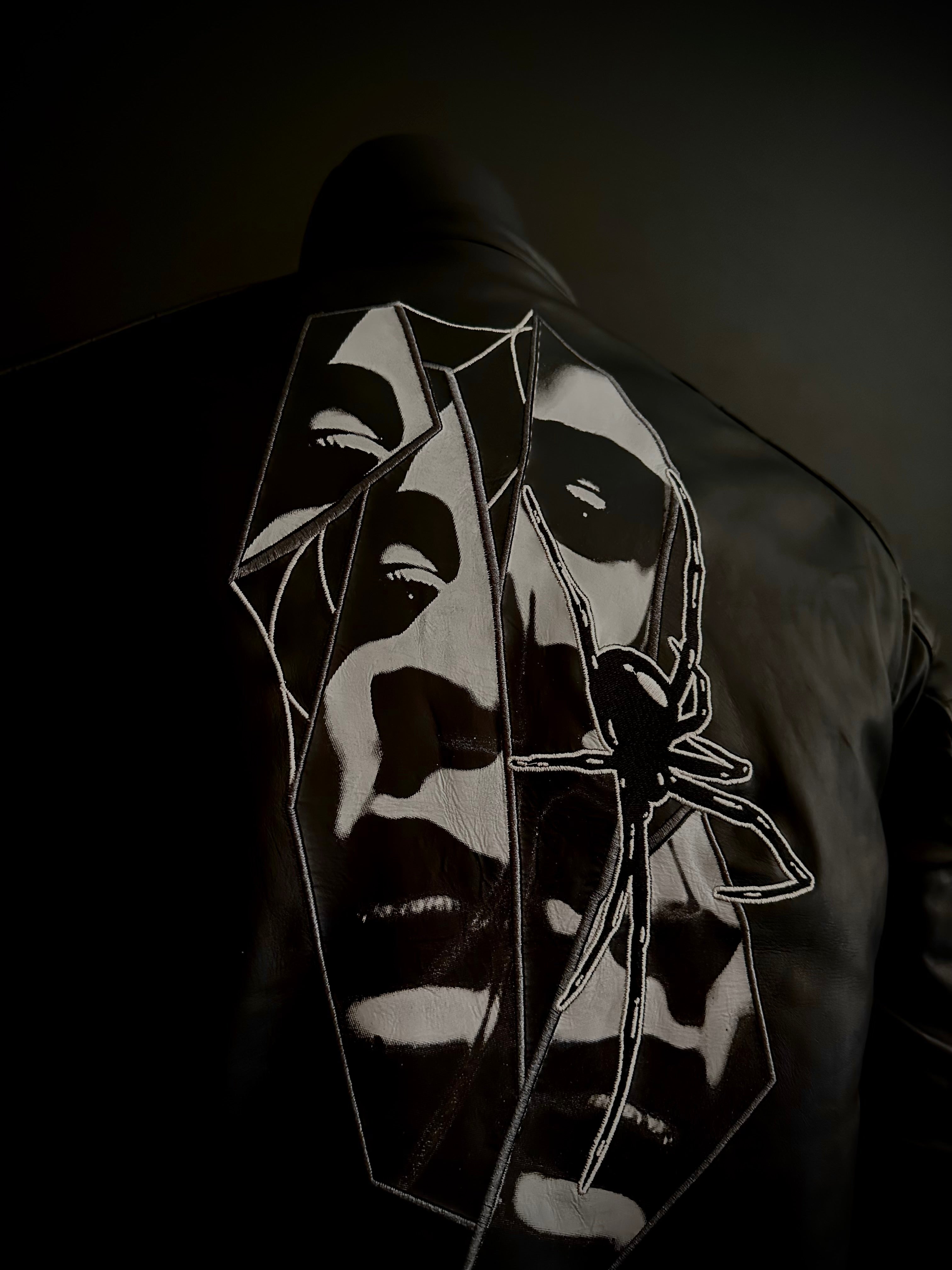 Back of black motorcycle leather jacket with spider embroidery and art